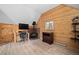 Cozy living room featuring wood-paneled walls, fireplace, and a functional desk area at 356 Castlewood Dr, Evergreen, CO 80439