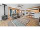 Cozy living room with a wood-burning stove, wood accents, and an open floor plan to the kitchen, perfect for relaxing at 356 Castlewood Dr, Evergreen, CO 80439