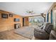 Inviting living area with wood-paneled walls, a cozy fireplace, and a sunroom with picturesque nature views at 356 Castlewood Dr, Evergreen, CO 80439