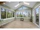 Bright sunroom featuring vaulted ceilings, skylights, large windows and wood-look tile flooring at 356 Castlewood Dr, Evergreen, CO 80439