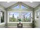 Bright sunroom with vaulted ceilings and large windows showcasing scenic views of the surrounding forest at 356 Castlewood Dr, Evergreen, CO 80439