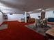 Spacious finished basement area with red carpet, lounge furniture, and a dining table with seating at 8908 Jellison Ct, Westminster, CO 80021