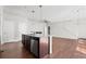 Open-concept kitchen featuring an island with pendant lights, wood floors, and stainless steel appliances at 10859 E 25Th Dr, Aurora, CO 80010
