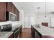 Well-lit kitchen showcasing granite countertops, stainless steel appliances, and dark wood cabinetry at 10859 E 25Th Dr, Aurora, CO 80010