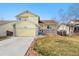 Charming yellow two-story home featuring an attached garage and inviting front porch at 13463 Quivas St, Westminster, CO 80234