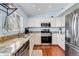 Bright kitchen features stainless steel appliances, granite counters, and wood floors at 13463 Quivas St, Westminster, CO 80234