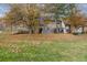 Lush backyard featuring mature trees, green grass, and a charming home exterior at 2182 S Victor St # D, Aurora, CO 80014
