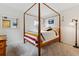 Bright bedroom featuring a four-poster bed, soft carpet, and stylish decor at 2182 S Victor St # D, Aurora, CO 80014