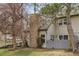Charming home exterior with stone chimney, a gray fence and mature trees at 2182 S Victor St # D, Aurora, CO 80014