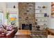Bright living room with a stone fireplace, decorative shelves, and comfortable seating at 2182 S Victor St # D, Aurora, CO 80014
