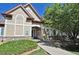 Exterior view of a building with beige siding, stacked stone accents, and landscaped pathway at 9568 W San Juan Cir # 307, Littleton, CO 80128