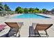 Large community pool with lounge chairs and tables, surrounded by lush green trees and landscaping at 9568 W San Juan Cir # 307, Littleton, CO 80128