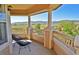 Covered porch with chairs and pillows and a great view of open space and mountains at 9568 W San Juan Cir # 307, Littleton, CO 80128