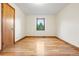 Spacious bedroom featuring hardwood floors and a window with a green, wooded view at 3665 Estes St, Wheat Ridge, CO 80033