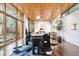 Bright dining area featuring wood ceilings, large windows, and a modern dining set with a hide rug underneath at 3665 Estes St, Wheat Ridge, CO 80033
