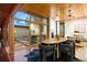 Bright dining area featuring wood ceilings, large windows, and a modern dining set with views of a courtyard at 3665 Estes St, Wheat Ridge, CO 80033