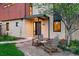 Inviting front entrance with stucco exterior, modern lighting, and chairs with a table on the patio at 3665 Estes St, Wheat Ridge, CO 80033
