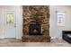Close up of stone fireplace with wood burning insert, hearth, and a view to a side window at 1500 Buckeye Cir, Georgetown, CO 80444