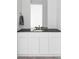 Elegant bathroom vanity with white cabinets, black countertop, modern faucet, and a large mirror at 12965 Grassland St, Longmont, CO 80504