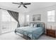 Bright bedroom featuring a comfortable bed, bedside tables, and sliding glass doors to a private balcony at 12965 Grassland St, Longmont, CO 80504