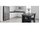Modern kitchen boasts stainless steel refrigerator, white cabinets, dark countertops, and a stylish breakfast bar at 12965 Grassland St, Longmont, CO 80504