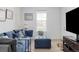 Inviting living room featuring a comfortable blue sofa, ottoman, and bright natural light from a large window at 12965 Grassland St, Longmont, CO 80504