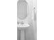 Clean and modern powder room with a pedestal sink, oval mirror, and fresh white walls at 12965 Grassland St, Longmont, CO 80504