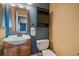 Cozy bathroom with pedestal sink, dark vanity, framed mirror, and toilet; a simple yet functional design at 5773 W 76Th Dr, Arvada, CO 80003