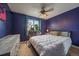 Cozy bedroom illuminated with natural light, showcasing plant decor and a functional ceiling fan at 5773 W 76Th Dr, Arvada, CO 80003
