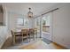 Cozy dining space featuring natural wood furniture, a modern light fixture, and deck access at 5773 W 76Th Dr, Arvada, CO 80003