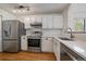 Modern kitchen featuring white cabinets, stainless steel appliances, and ample counter space at 5773 W 76Th Dr, Arvada, CO 80003