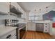Bright kitchen features stainless steel appliances, white cabinets, and quartz countertops at 5773 W 76Th Dr, Arvada, CO 80003