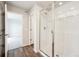 Bathroom featuring a glass shower and view through to the bedroom of this home at 2186 Flower Blossom Ave, Brighton, CO 80601