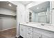 A modern bathroom featuring double sinks, white cabinetry, a large mirror, and a glass-enclosed shower at 2186 Flower Blossom Ave, Brighton, CO 80601