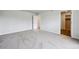 A spacious bedroom with neutral tones, plush carpeting, and an open doorway to an adjoining space at 2186 Flower Blossom Ave, Brighton, CO 80601