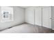 A bright bedroom with natural light, neutral carpeting, and a closet with sliding doors at 2186 Flower Blossom Ave, Brighton, CO 80601