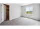 A bedroom filled with light from its large window, plush carpeting, and an adjacent closet at 2186 Flower Blossom Ave, Brighton, CO 80601