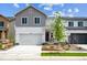 Charming two-story home showcasing a gray and white exterior, attached garage, and freshly landscaped front yard at 2186 Flower Blossom Ave, Brighton, CO 80601