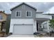 Two-story home featuring a two-car garage, a covered front porch, and two-toned gray and white siding at 2186 Flower Blossom Ave, Brighton, CO 80601