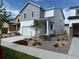 Charming two-story home featuring a gray and white exterior, a well-manicured lawn, and a two car garage at 2186 Flower Blossom Ave, Brighton, CO 80601
