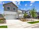 Modern two-story home featuring a gray and white exterior, attached garage, and landscaped front yard at 2186 Flower Blossom Ave, Brighton, CO 80601