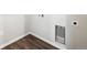 Corner of laundry room showcasing hookups, dark LVP flooring, and white trim at 2186 Flower Blossom Ave, Brighton, CO 80601