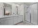 Modern bathroom featuring double sinks, marble countertops, and a glass-enclosed shower at 730 Cottonwood Ave, Bennett, CO 80102