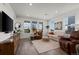 Bright living room featuring hardwood floors, large windows, and stylish modern decor at 730 Cottonwood Ave, Bennett, CO 80102