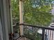 Cozy balcony area with metal railing overlooking lush green trees and street parking at 7369 S Alkire St # 203, Littleton, CO 80127