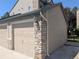 The side angle of a single-car garage with stone and siding design details at 7369 S Alkire St # 203, Littleton, CO 80127