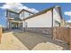 Side view of the backyard with a covered patio, gate access, and partial gravel landscaping at 21022 E 63 Dr, Aurora, CO 80019