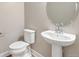 Powder room featuring a pedestal sink, elegant mirror, and a modern toilet in a neutral color palette at 21022 E 63 Dr, Aurora, CO 80019