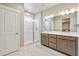 Bathroom with a double sink vanity, a frameless shower, and stylish tile flooring at 21022 E 63 Dr, Aurora, CO 80019