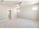 Large bedroom with neutral walls, plush carpeting, ceiling fan and a doorway to the en-suite bathroom at 21022 E 63 Dr, Aurora, CO 80019
